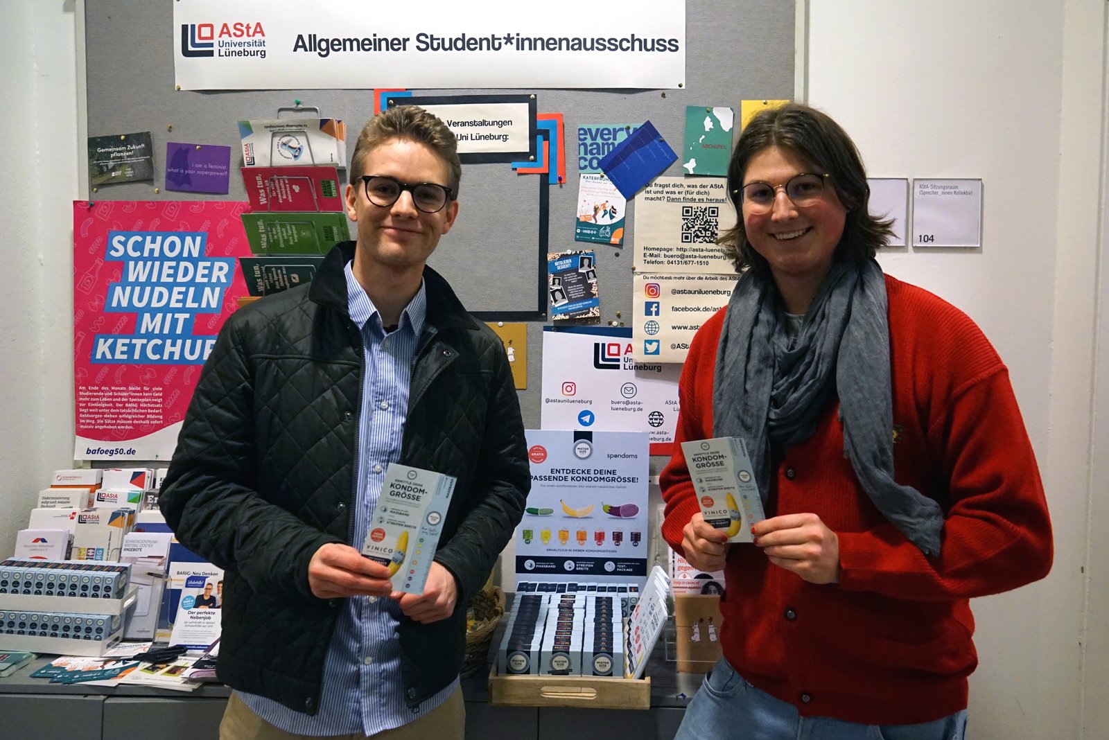 Luis Spondomsist (vasakul) avab koos Maxiga Leuphana Ülikooli Lüneburgi AStA-st (paremal) tasuta kondoomide jaotusvahendi.